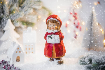 Retro Christmas card with a cute figure of a child on a snowy background. A girl in a red coat...