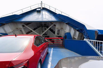 Front open door of passenger freight cargo ferry boat vessel ship with loaded cars and vehicles. Sea transportation ferryboat transport carrier unloading disembark. Northern Europe sea line