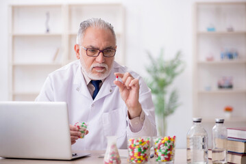 Old male doctor suggesting pills in the clinic