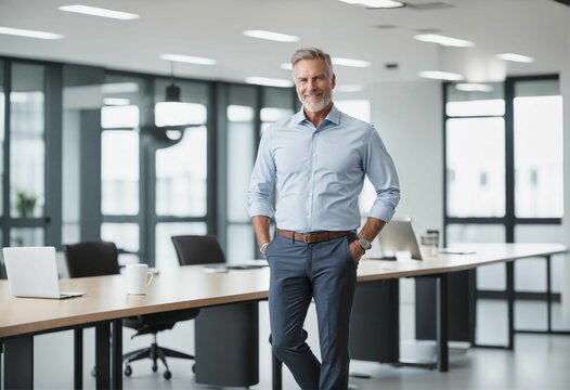Happy middle aged CEO standing confidently in office with hands in pockets