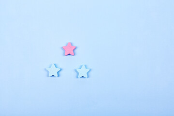 Three different color wooden stars shapes symbol label form isolated on the bright solid fond plain...
