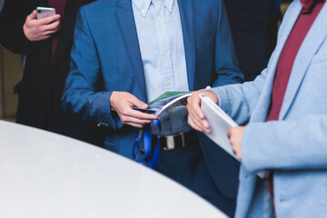 Process of checking in on a conference congress forum event, registration desk table, visitors and attendees receiving a name badge and entrance wristband bracelet and register electronic ticket