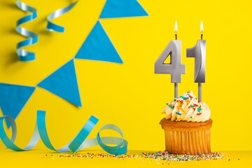 Lighted birthday candle number 41 - Yellow background with blue pennants
