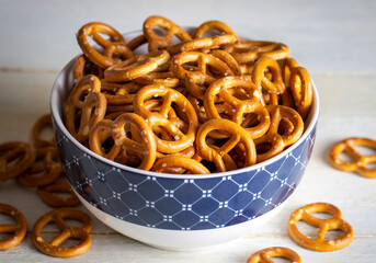 Mini pretzels with salt on wooden background. Selective focus.