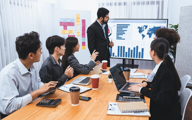 Businessman presenting data analysis dashboard display on TV screen in modern meeting for marketing strategy. Business presentation with group of business people in conference room. Concord