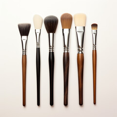 Fondo con detalle y textura de varios pinceles con mango de madera y diferentes tonos, con fondo de tonos claros