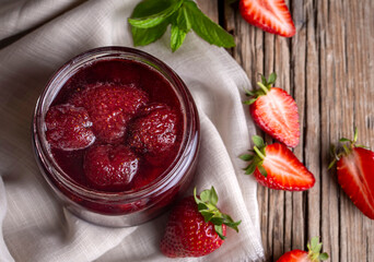 Homemade delicious strawberry jam and strawberry on a rustic wooden table
