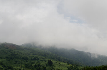 Clouds float in the mountains, high above sea level, green mountains