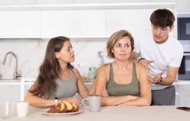 Obraz na płótnie Canvas Adult children calm their mother after a domestic quarrel