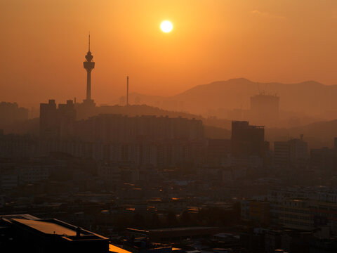 Daegu City Skyline at Sunrise in South Korea over the Apsan Mountains and Daegu 83 Tower in the fog and smog, tranquil cityscape of the old textile industry powerhouse in Asia