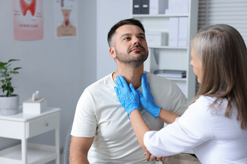 Endocrinologist examining thyroid gland of patient at hospital