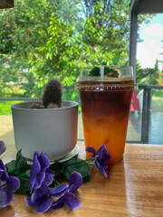 Orange black coffee on a wooden bar with a view of nature.