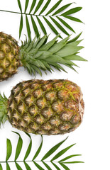 Whole ripe pineapples and green leaves on white background, flat lay. Space for text