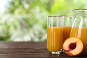 Tasty peach juice and fresh fruit on wooden table outdoors, space for text
