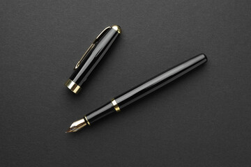 Stylish fountain pen with cap on black background, flat lay
