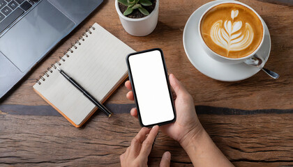 hand holding and using a smartphone with blank desktop screen while working and drinking coffee in cafe. Mockup mobile phone. - Powered by Adobe