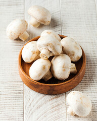 Fresh mushrooms in a wooden plate on a light background. Mushroom 