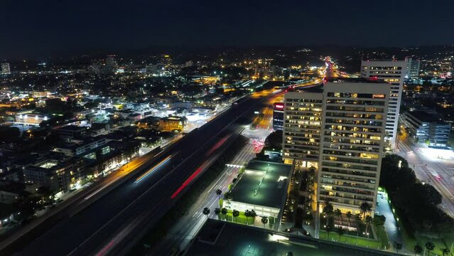 Aerial Lockdown Time Lapse Shot Of Vehicles On Bridge Amidst Buildings In Illuminated City At Night - Los Angeles, California