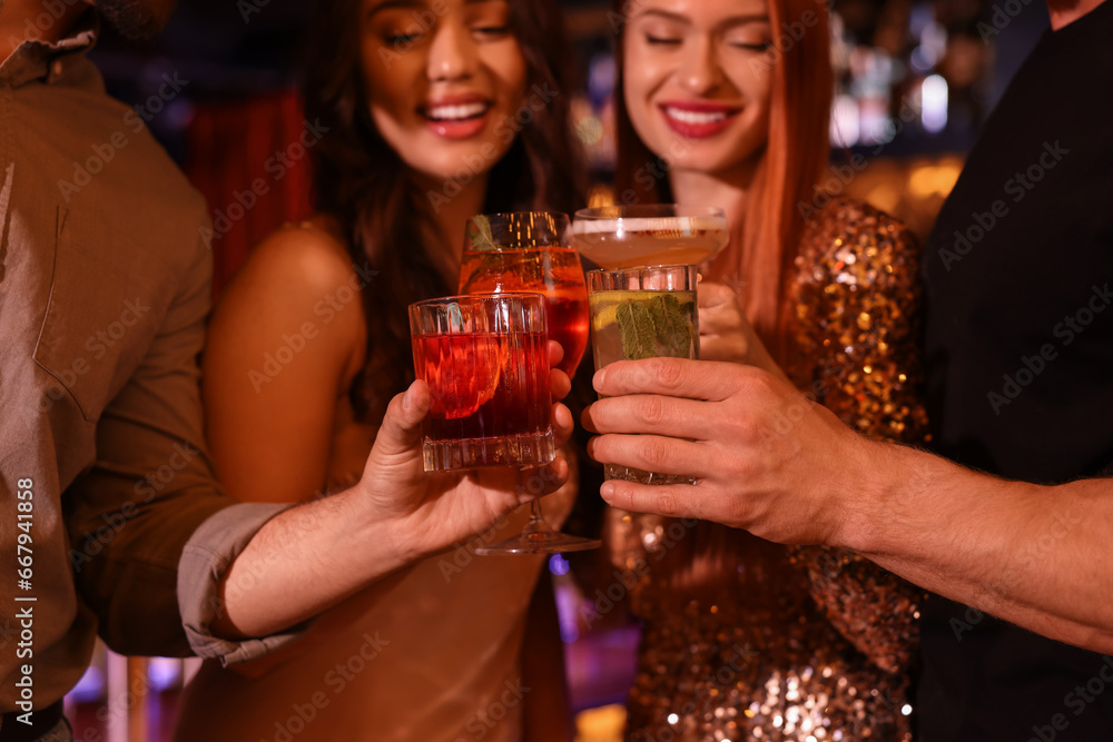 Poster Friends clinking glasses with fresh cocktails in bar, selective focus