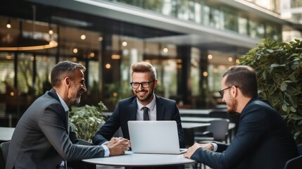 Businessmen talk together and use laptops The background is sorted on the copy space.