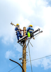 Workers are repairing electricity on overhead poles in Ho Chi Minh City, Vietnam.