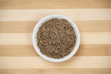Top view of cumin seeds on wooden background, jeera