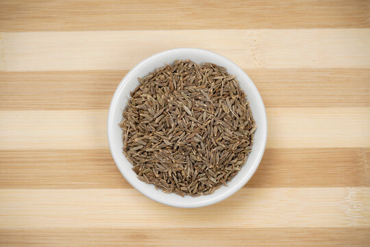 Top view of cumin seeds on wooden background, jeera