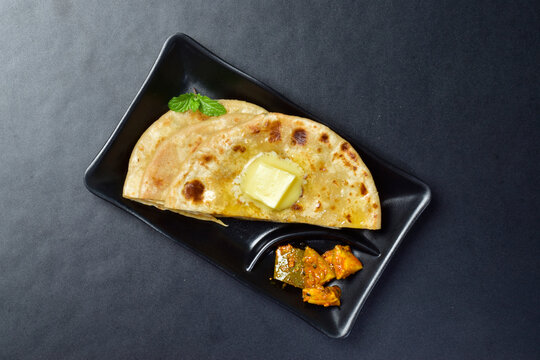 Butter paratha with pickle in plate, delicious indian food