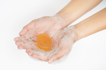 Hand holding bar of soap on white background