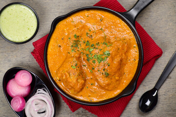Creamy butter chicken in plate with mint chutney