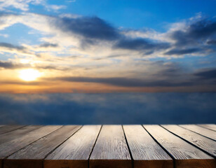 Fototapeta na wymiar Empty wooden table against the backdrop of a blurred blue sky sunrise background. High quality photo