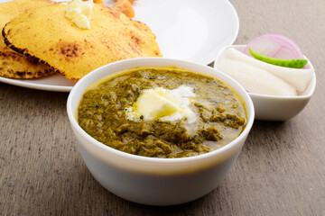 Bowl of sarson saag with white makhan on table
