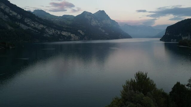 A stunning view of Lake Walensee's tranquil waters and mountain backdrop at sunrise