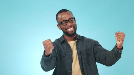 Black man, fist pump and celebration with happiness, winner in studio and success isolated on blue background. Cheers, excited and winning competition with achievement, giveaway or reward with pride