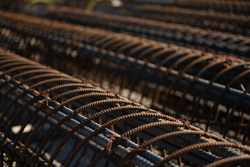 At a construction site, there is an array of round mesh reinforcements for building concrete support columns. The circular rebar rings fade away into the distance, expressing the scale of the project.