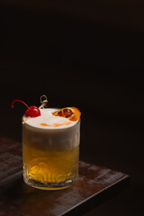 Sour cocktail with cherry and orange.
