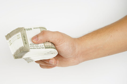 Bundle of indian rupees in hand on white background