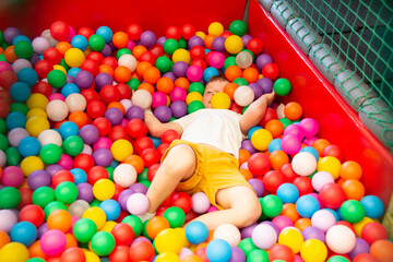 Fototapeta na wymiar Boy playing on the playground, in the children's maze with balls.