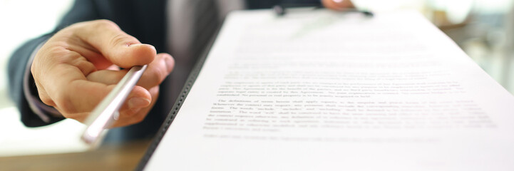 Manager gives contract papers and pen to partner in office
