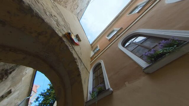 Lithuanian Flag Above the Arch in the Narrow Old Town Street in Vilnius, Lithuania. Slow Motion Footage