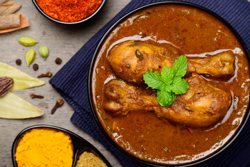 Top view of chicken masala curry in bowl, chicken leg piece