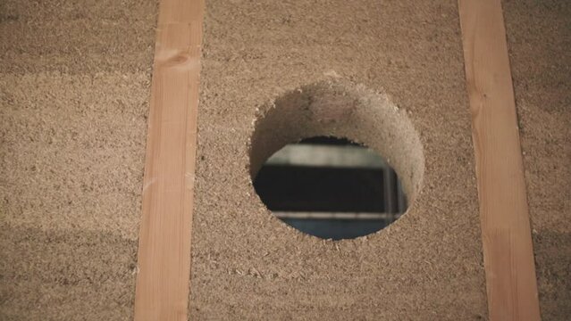 Detail view of a hempcrete wall in wooden frame with a round opening window unter construction