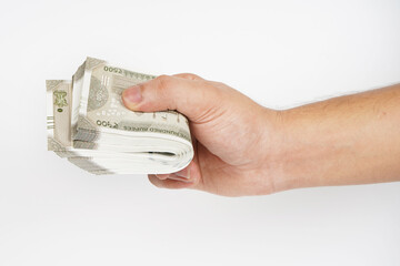 Hand holding pile of cash on white background, indian currency note