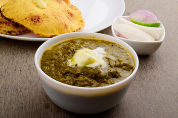 Closeup of sarson saag bowl with white butter at table