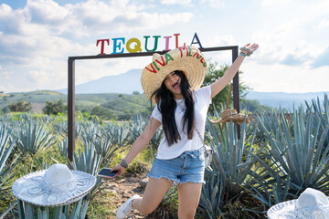 La joven está feliz en el campo de agaves del pueblo de Tequila Jalisco México.