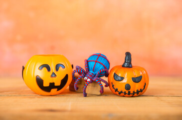 Halloween pumpkin with blue yarn spider over blurred space on orange cement wall, Happy halloween card background idea
