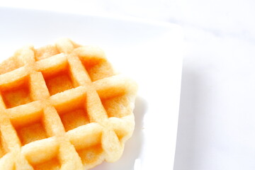 バターをたっぷり使って焼き上げた格子模様の洋菓子のワッフル