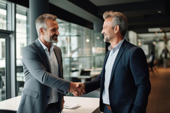 Smiling middle aged business man handshaking partner, making partnership collaboration agreement at office meeting. HR manager and new worker shake hands recruiting at job interview. 