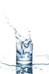 Ice cubes dropping into a glass of water