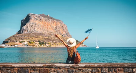 Foto op Plexiglas Happy woman tourist with bag and flag enjoying vacation in Greece- Monemvasia island © M.studio
